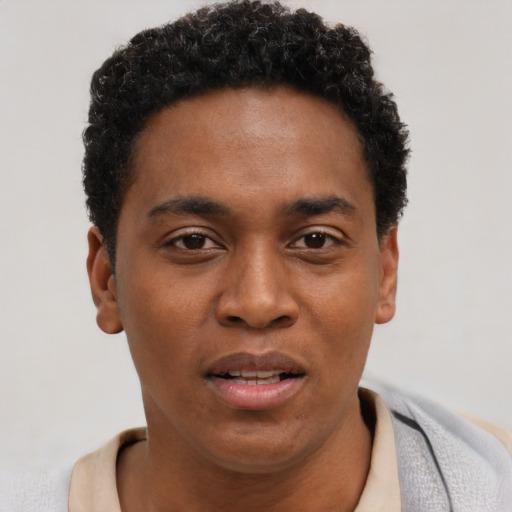 Joyful black young-adult male with short  brown hair and brown eyes