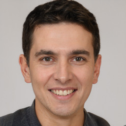 Joyful white young-adult male with short  brown hair and brown eyes