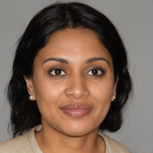 Joyful black young-adult female with medium  black hair and brown eyes