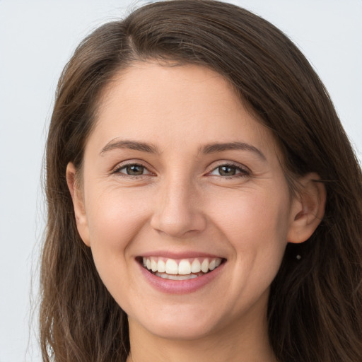 Joyful white young-adult female with long  brown hair and grey eyes