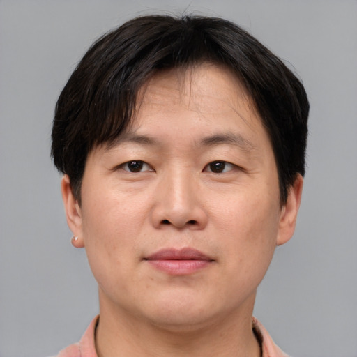 Joyful asian adult male with short  brown hair and brown eyes