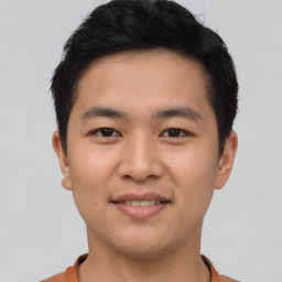 Joyful asian young-adult male with short  black hair and brown eyes