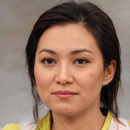 Joyful asian adult female with medium  brown hair and brown eyes