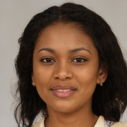 Joyful black young-adult female with long  brown hair and brown eyes