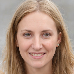 Joyful white young-adult female with long  brown hair and green eyes