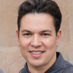 Joyful white adult male with short  brown hair and brown eyes