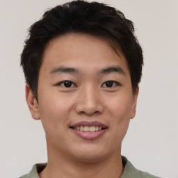 Joyful asian young-adult male with short  brown hair and brown eyes