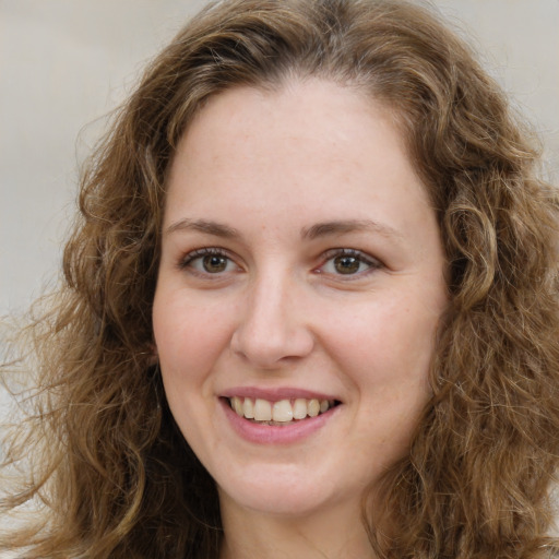 Joyful white young-adult female with long  brown hair and green eyes