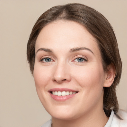 Joyful white young-adult female with medium  brown hair and grey eyes