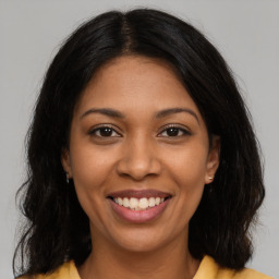 Joyful latino young-adult female with long  brown hair and brown eyes