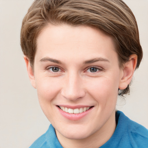 Joyful white young-adult female with short  brown hair and blue eyes