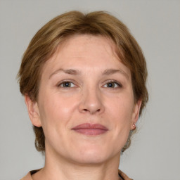 Joyful white adult female with medium  brown hair and grey eyes