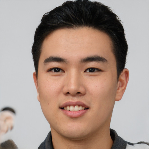 Joyful asian young-adult male with short  brown hair and brown eyes