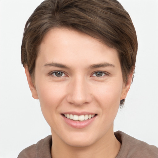 Joyful white young-adult female with short  brown hair and grey eyes