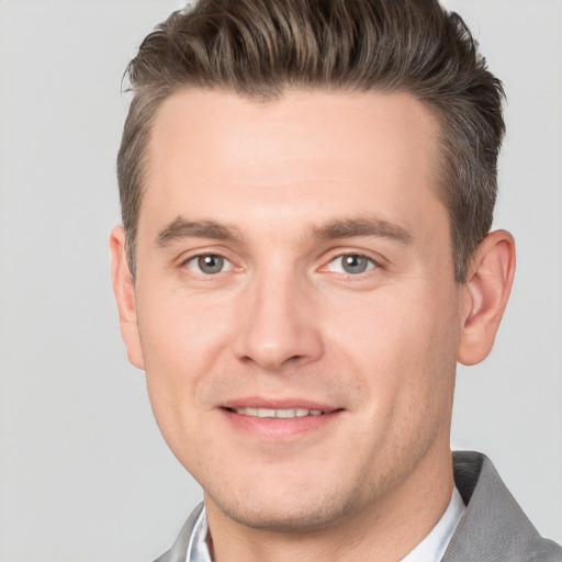 Joyful white young-adult male with short  brown hair and grey eyes