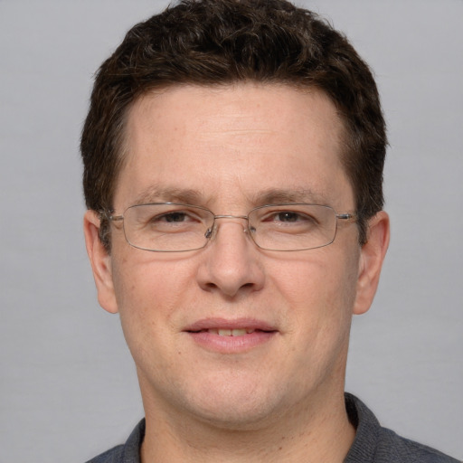 Joyful white adult male with short  brown hair and grey eyes