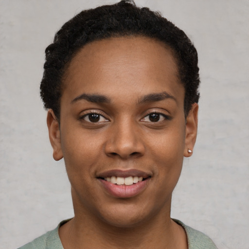 Joyful black young-adult female with short  black hair and brown eyes