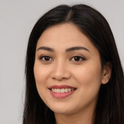 Joyful latino young-adult female with long  brown hair and brown eyes