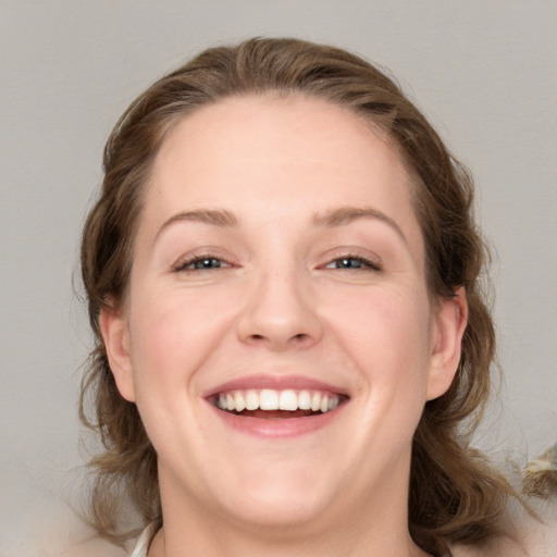 Joyful white young-adult female with medium  brown hair and blue eyes