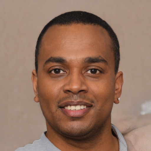Joyful black young-adult male with short  black hair and brown eyes
