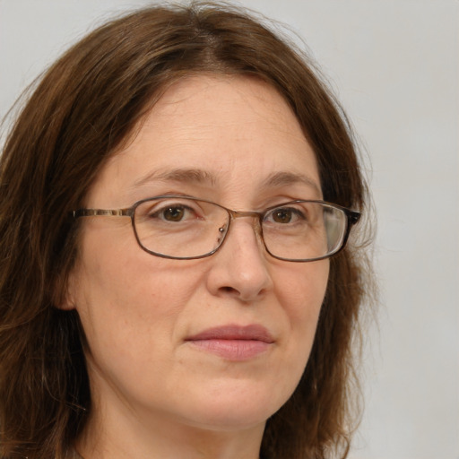 Joyful white adult female with long  brown hair and green eyes