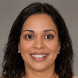 Joyful latino young-adult female with long  brown hair and brown eyes