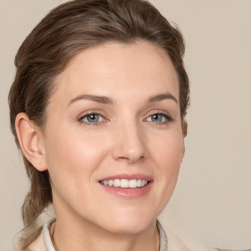 Joyful white young-adult female with medium  brown hair and grey eyes