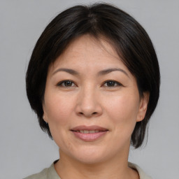 Joyful asian adult female with medium  brown hair and brown eyes