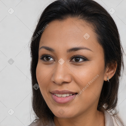 Joyful latino young-adult female with long  brown hair and brown eyes