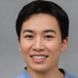 Joyful asian young-adult male with short  brown hair and brown eyes