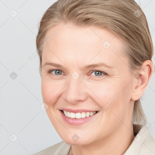 Joyful white young-adult female with medium  brown hair and grey eyes