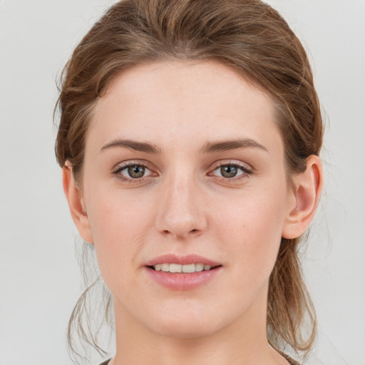 Joyful white young-adult female with medium  brown hair and grey eyes