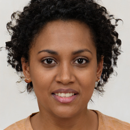 Joyful black young-adult female with short  brown hair and brown eyes