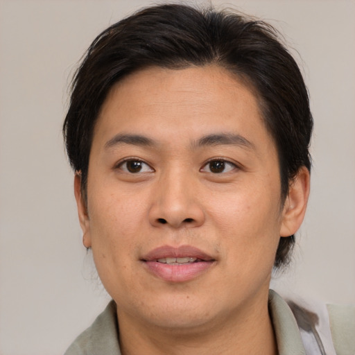 Joyful asian young-adult male with medium  brown hair and brown eyes