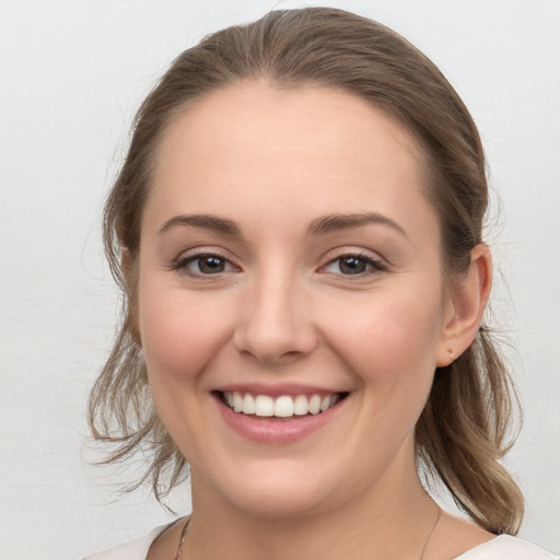 Joyful white young-adult female with medium  brown hair and grey eyes