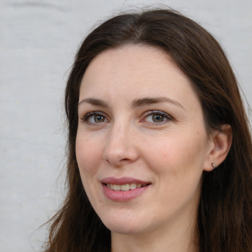 Joyful white adult female with long  brown hair and brown eyes