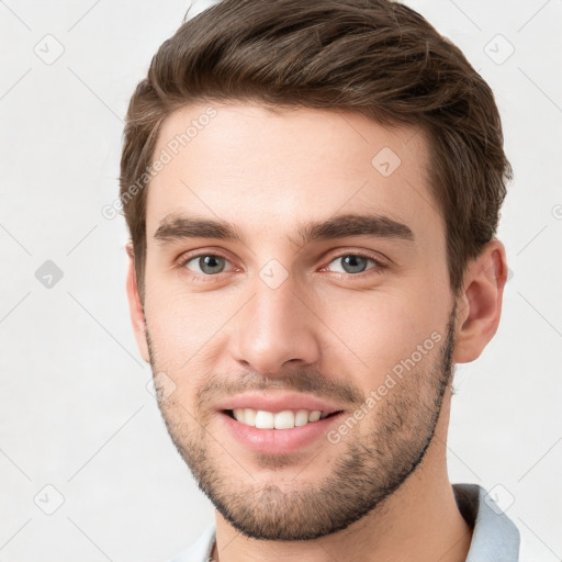 Joyful white young-adult male with short  brown hair and grey eyes