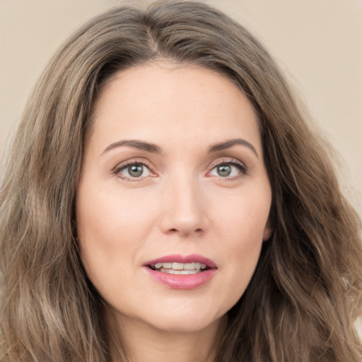 Joyful white young-adult female with long  brown hair and green eyes