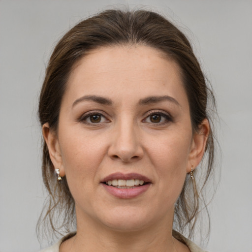 Joyful white young-adult female with medium  brown hair and grey eyes