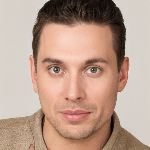 Joyful white young-adult male with short  brown hair and grey eyes