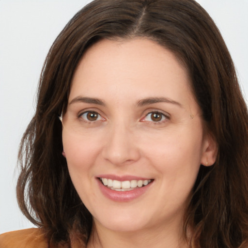 Joyful white young-adult female with long  brown hair and brown eyes