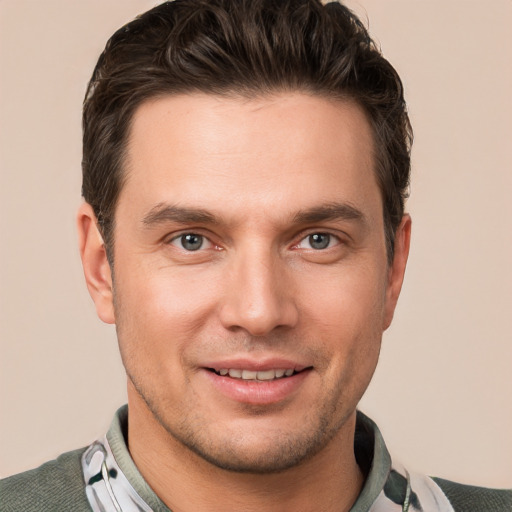 Joyful white young-adult male with short  brown hair and grey eyes