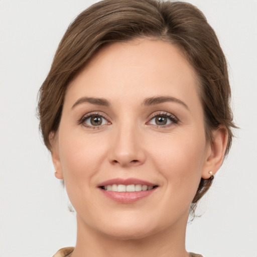 Joyful white young-adult female with medium  brown hair and grey eyes