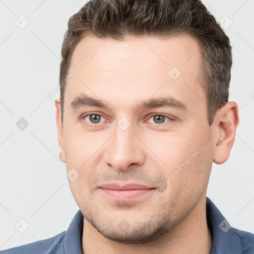 Joyful white young-adult male with short  brown hair and brown eyes