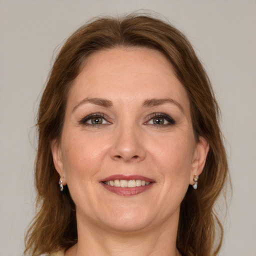 Joyful white adult female with long  brown hair and green eyes