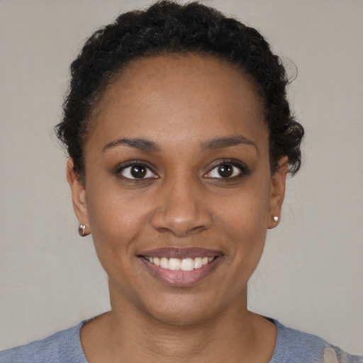 Joyful black young-adult female with short  brown hair and brown eyes