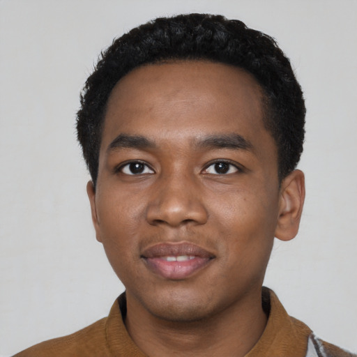Joyful black young-adult male with short  black hair and brown eyes