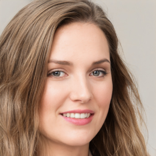 Joyful white young-adult female with long  brown hair and green eyes