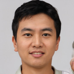 Joyful asian young-adult male with short  black hair and brown eyes