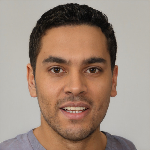 Joyful latino young-adult male with short  brown hair and brown eyes